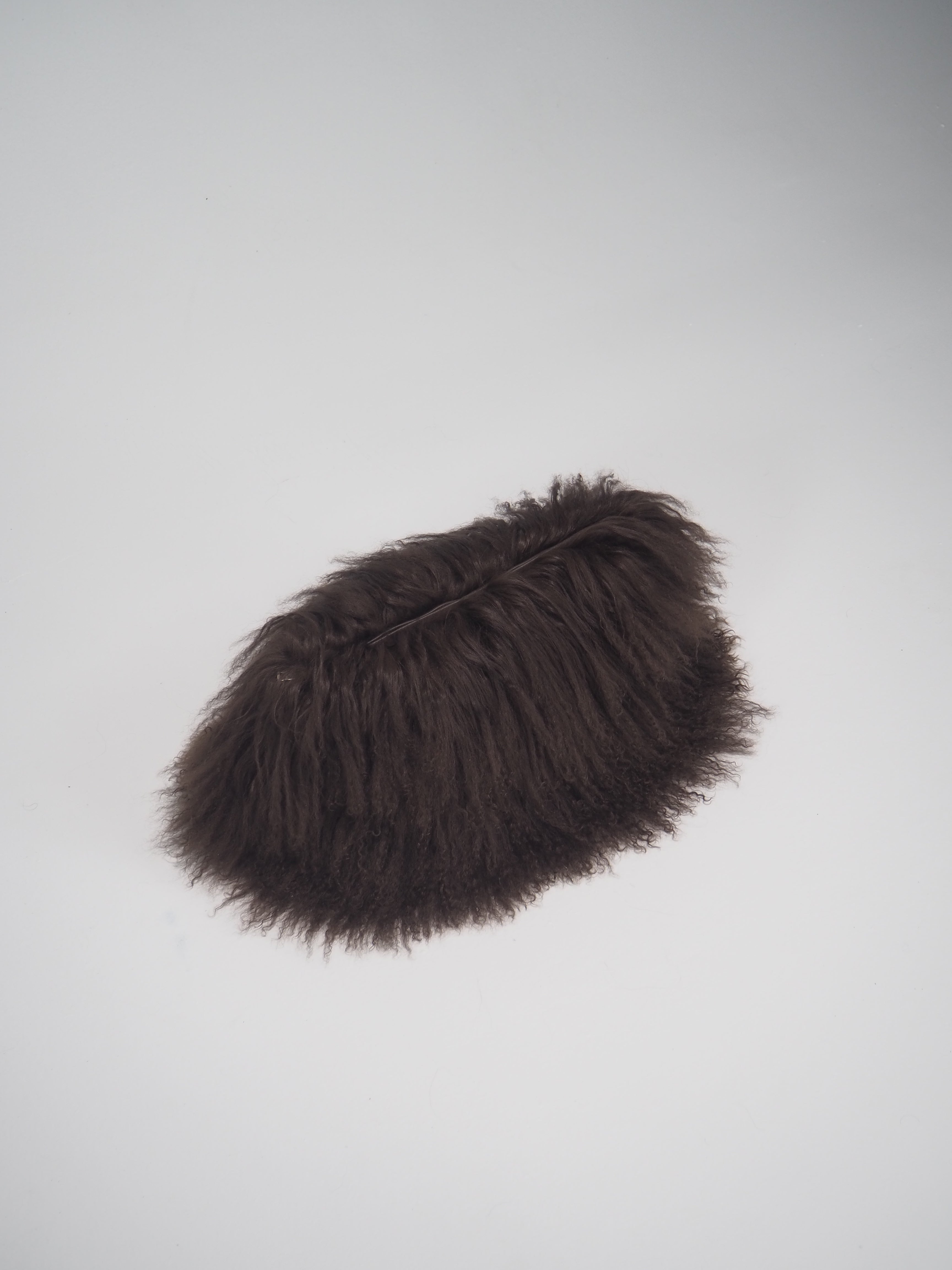 Brown fur clutch on a studio floor